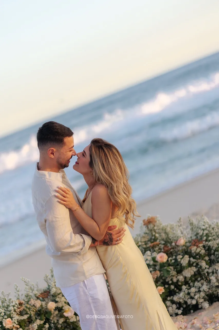 Casal recém-noivo nariz com nariz ao lado do jardim de flores