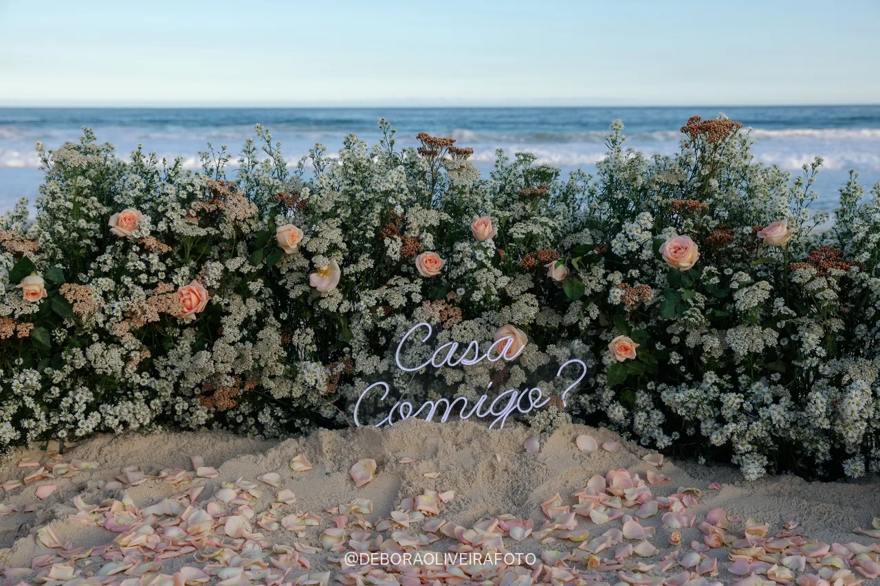 Placa Casa Comigo entre as flores na areia no Rio de Janeiro