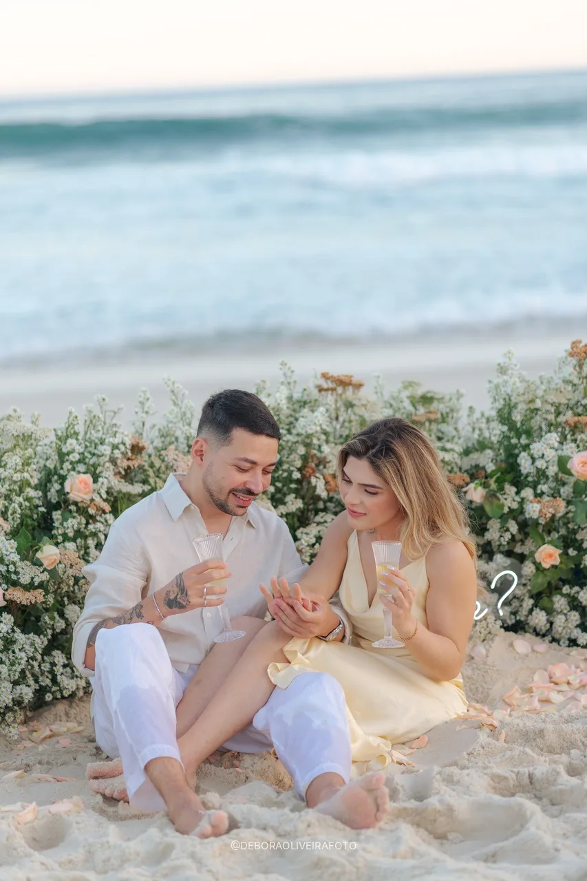 Casal sentado na areia em frente ao jardim de flores