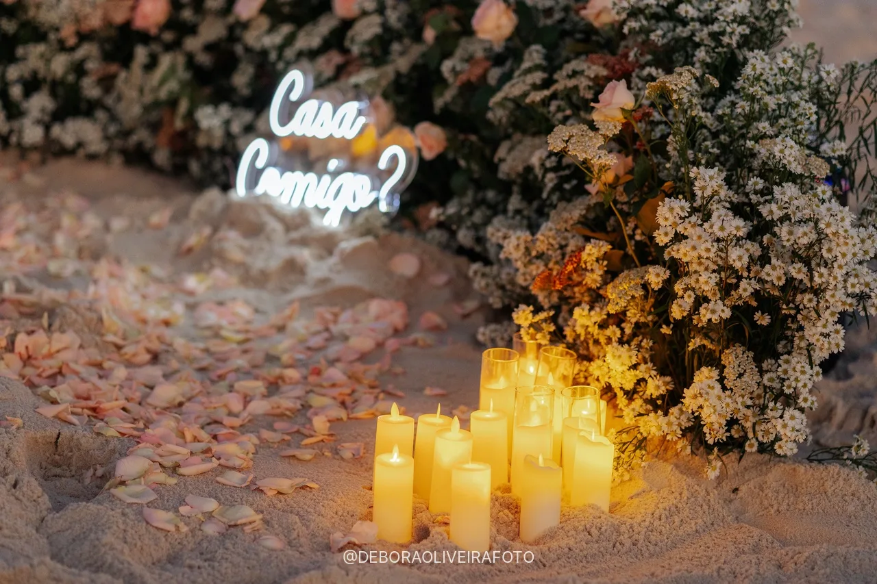 Placa neon Casa Comigo e velas acesas no fim do dia