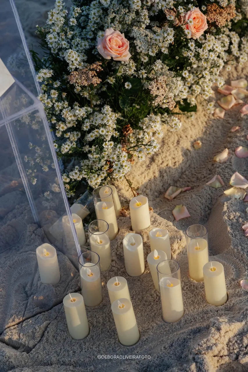 Velas na areia ao lado do jardim de flores