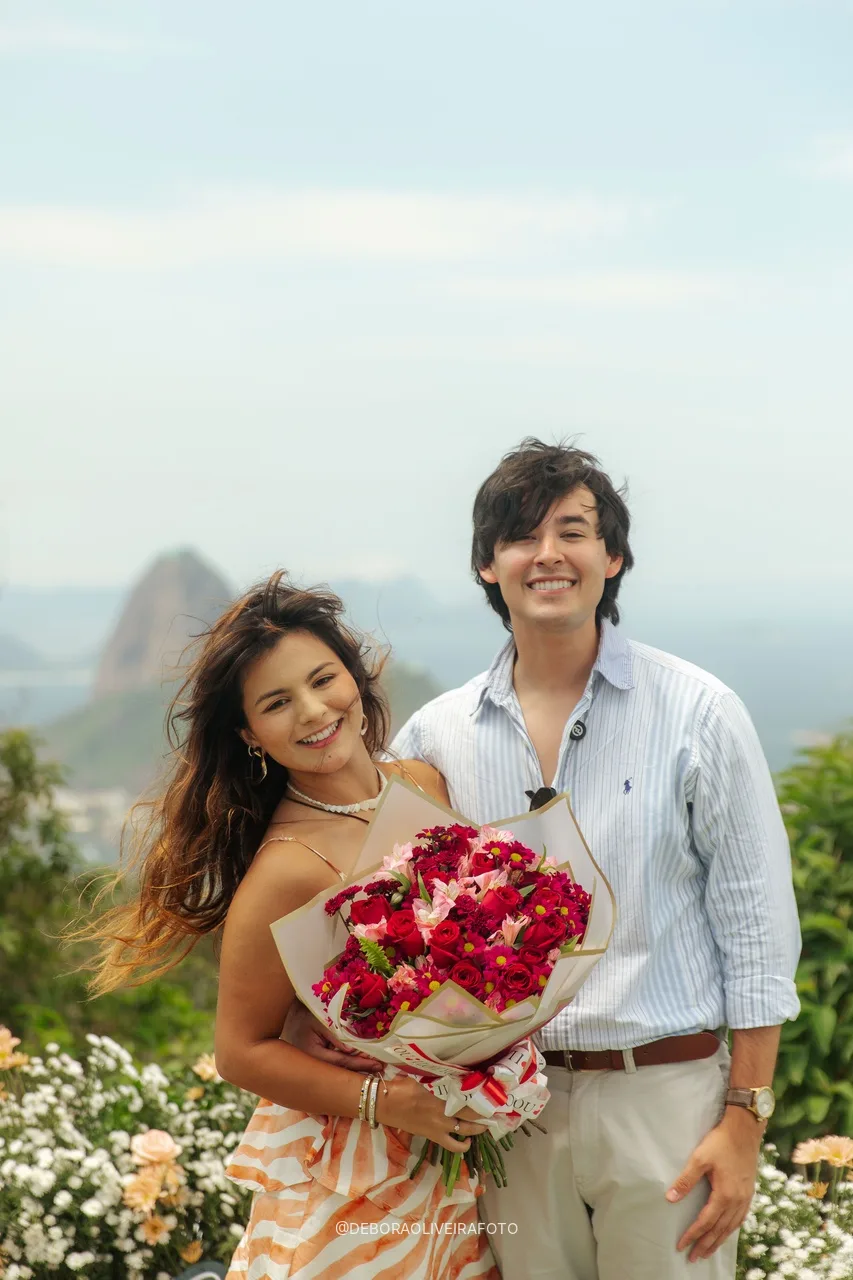 Pareja comprometida con el ramo de rosas rojas en el Mirante Dona Marta