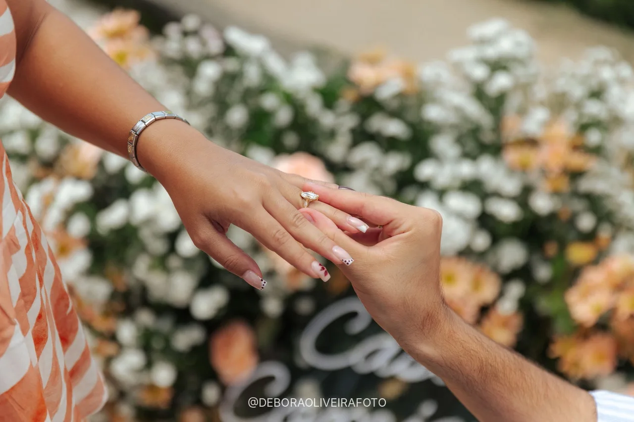 Detalle del anillo de compromiso en la mano de Alisha sobre las flores