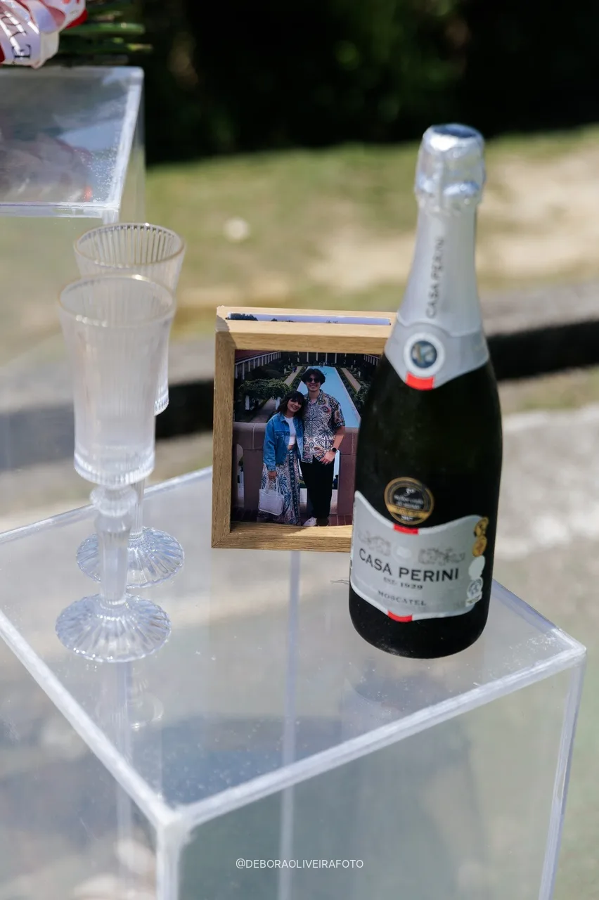 Espumante, copas y foto de la pareja en el soporte de acrílico