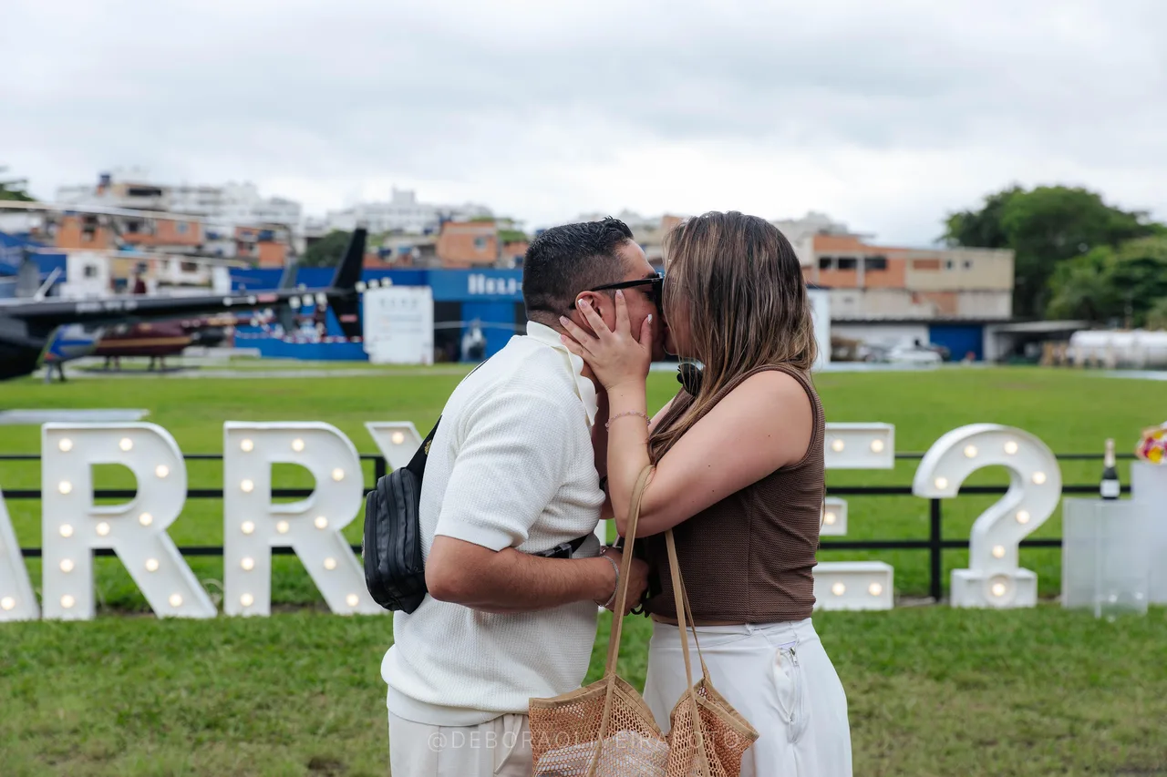 Juan and Andrea kissing after the yes in front of the Marry Me sign