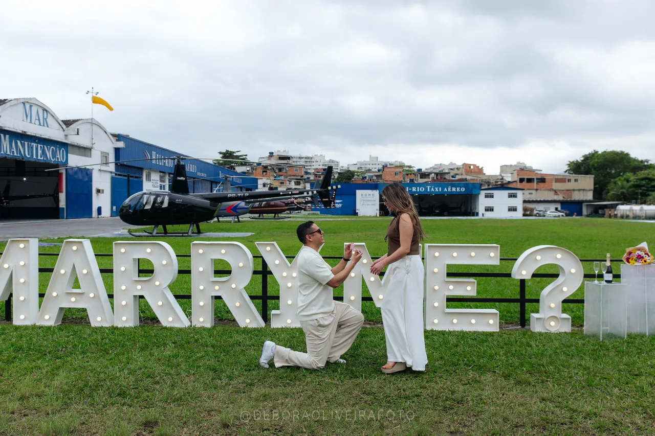Helicopter marriage proposal in Rio de Janeiro: Juan on one knee in front of the Marry Me sign