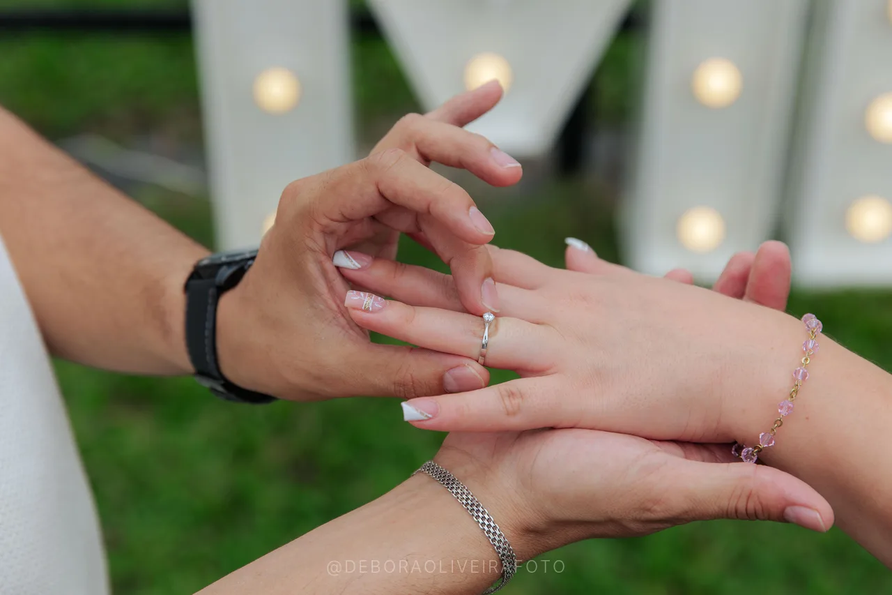 Engagement ring close-up on the lit Marry Me letters at the heliport