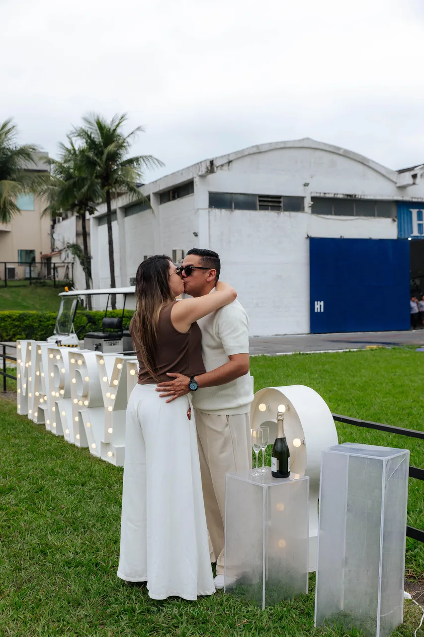 Couple embracing next to the Marry Me letters at a heliport in Rio de Janeiro