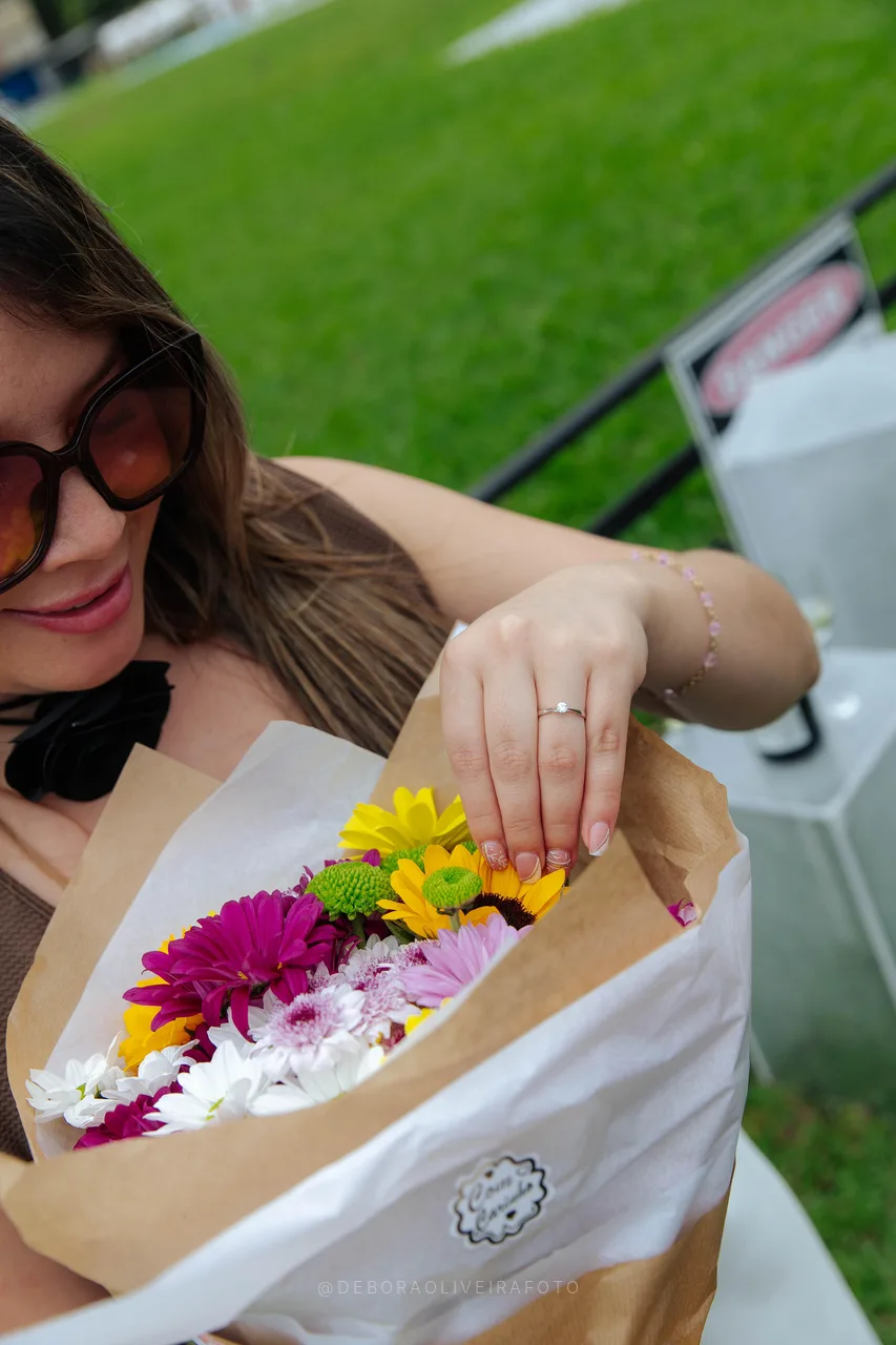 Andrea holding the flower bouquet with her engagement ring