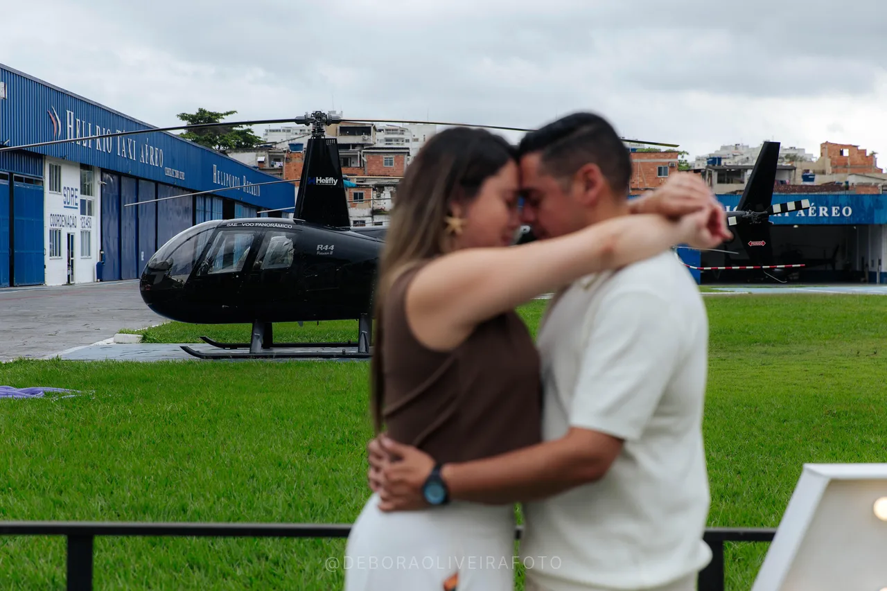 Engaged couple embracing in front of a helicopter in Rio de Janeiro