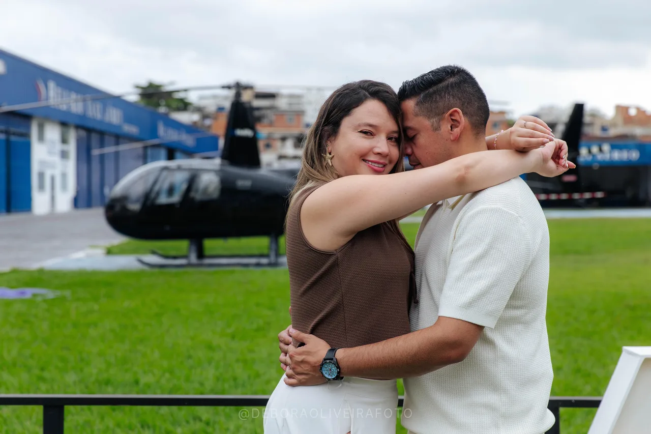 Juan and Andrea foreheads together in front of the helicopter