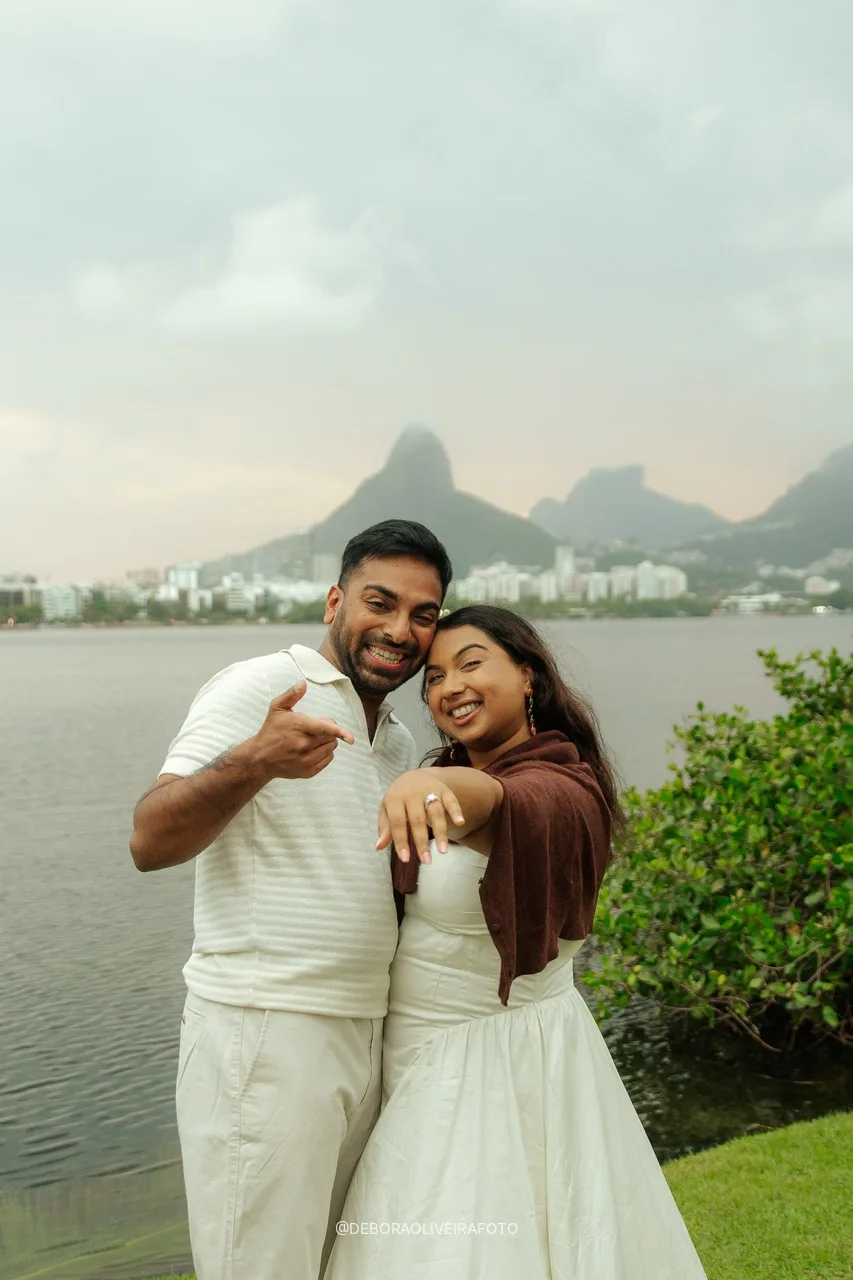 Naveen e Anisha mostrando o anel com a Lagoa ao fundo