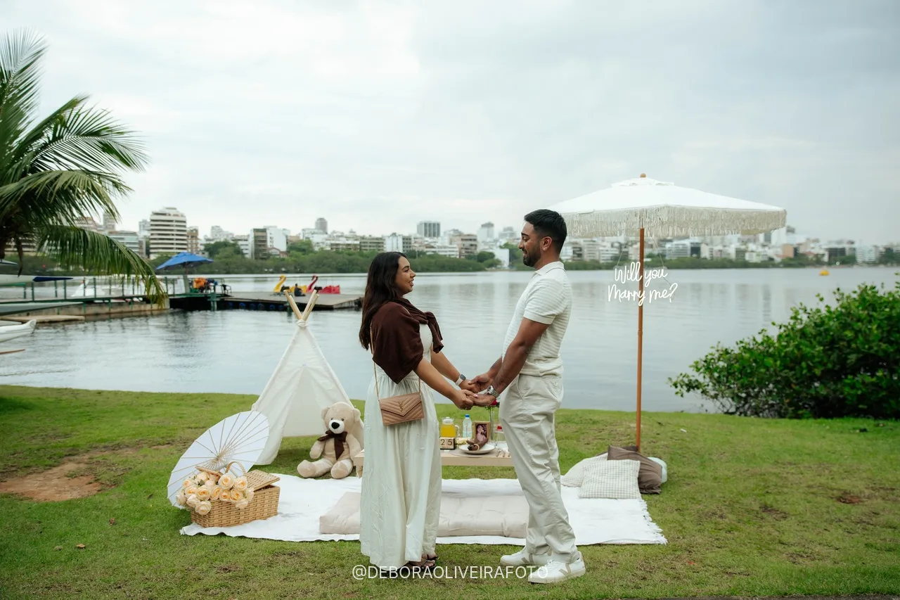 Naveen e Anisha de mãos dadas em frente ao piquenique na Lagoa