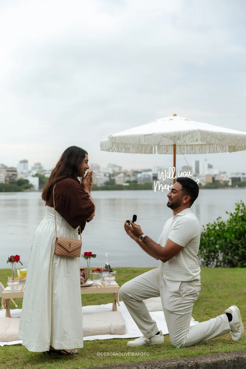 Naveen de joelho pedindo Anisha em casamento na Lagoa Rodrigo de Freitas