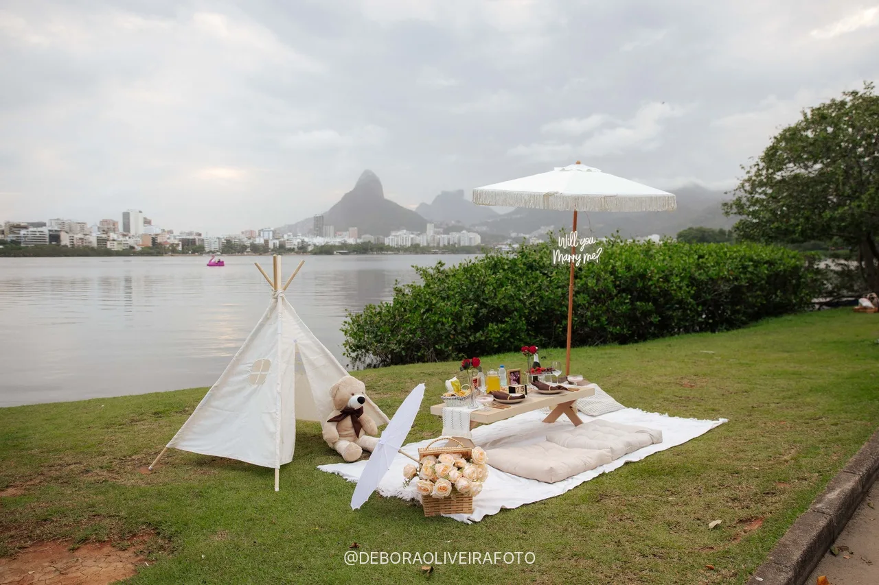 Tenda, mesa de piquenique e guarda-sol no gramado da Lagoa com o Dois Irmãos ao fundo