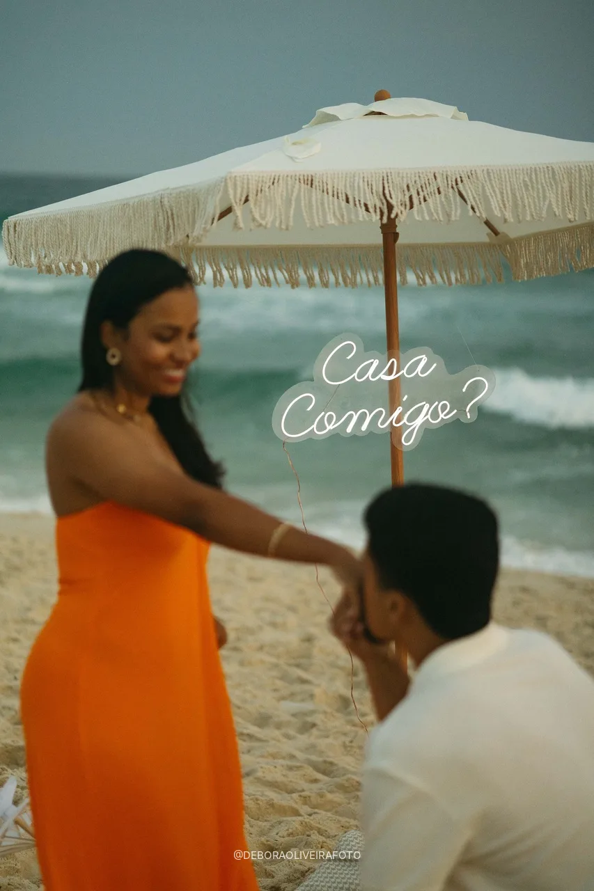 Samuel kissing Emile's hand under the Casa Comigo sign