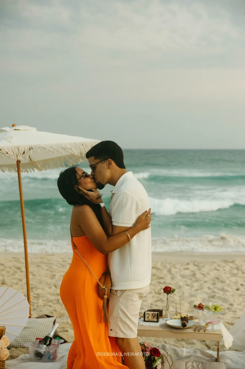 Couple kissing next to the picnic after the proposal
