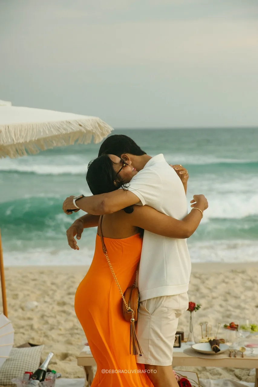 Emile and Samuel in a tight hug by the sea