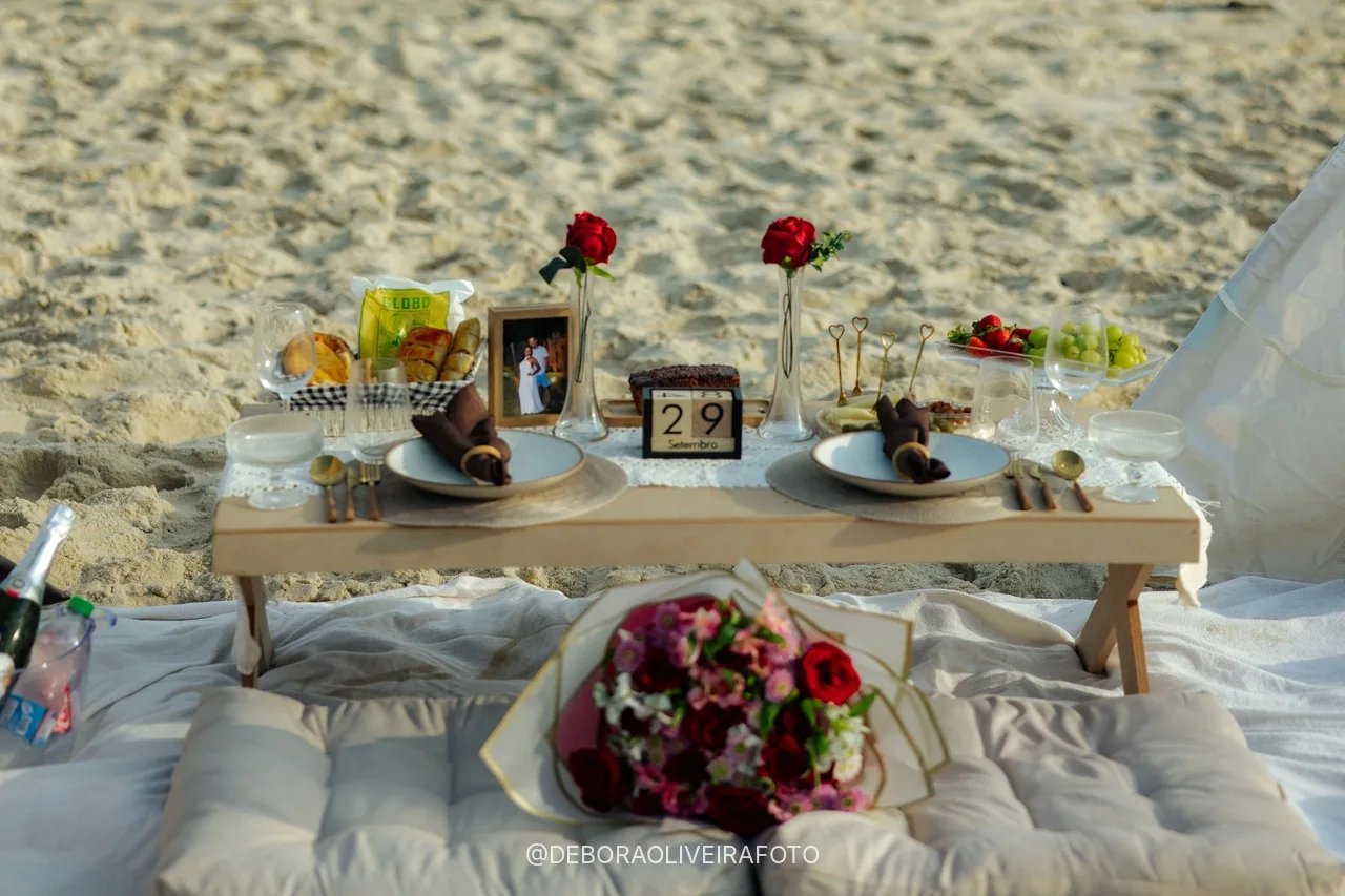 Flower bouquet and place settings on the beach picnic table