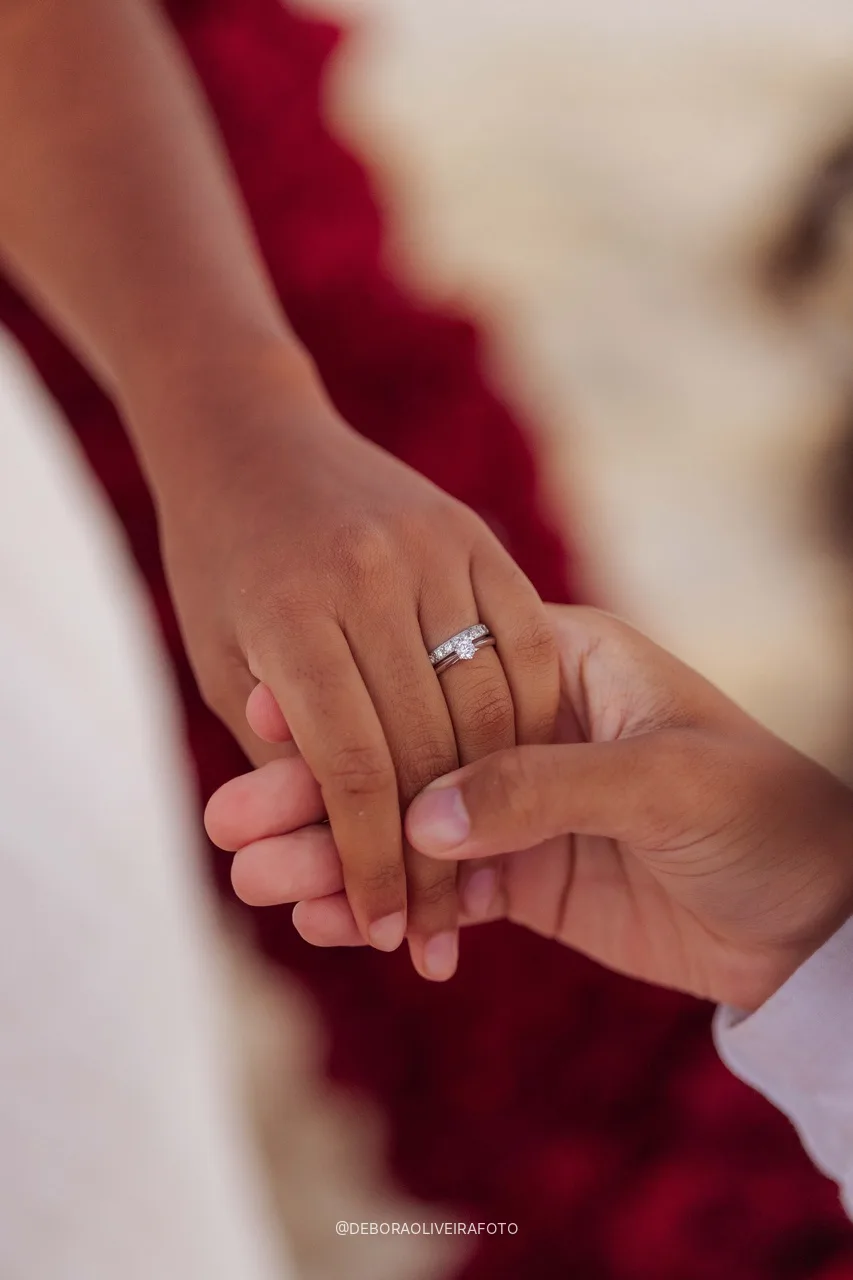 Detalle del anillo de compromiso con las rosas rojas de fondo