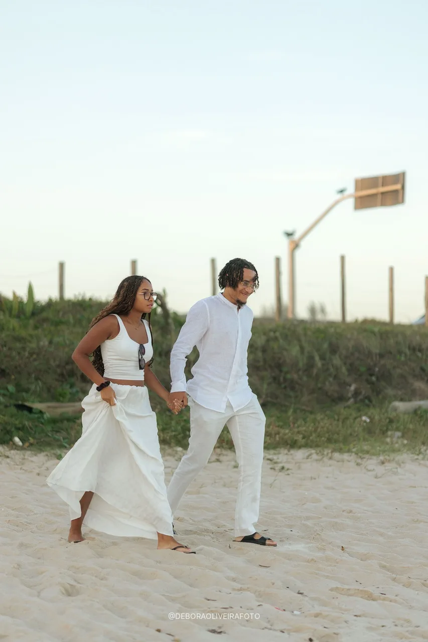 Pareja caminando por la arena hacia el montaje del pedido