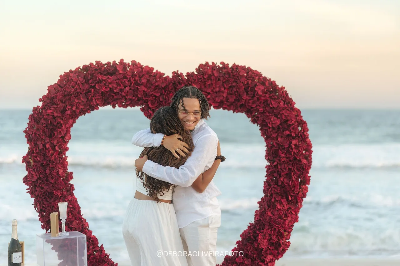 Pareja abrazada dentro del corazón de rosas rojas después del sí