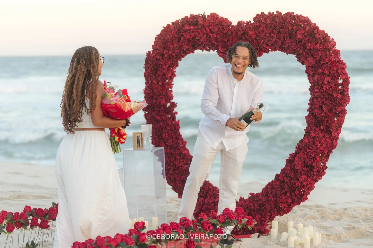 Stanley abriendo el espumante junto al arco de corazón